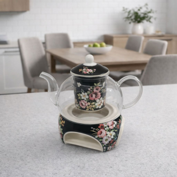 Sklenený čajník a keramický kvetinový ohrievadlom na čiernom podklade